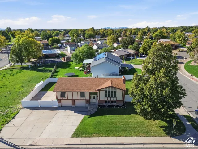 Tudor-style exterior featuring a multi-gabled roofline, brick and timber-frame facade, attached multi-car garage, white vinyl fencing, and a concrete driveway