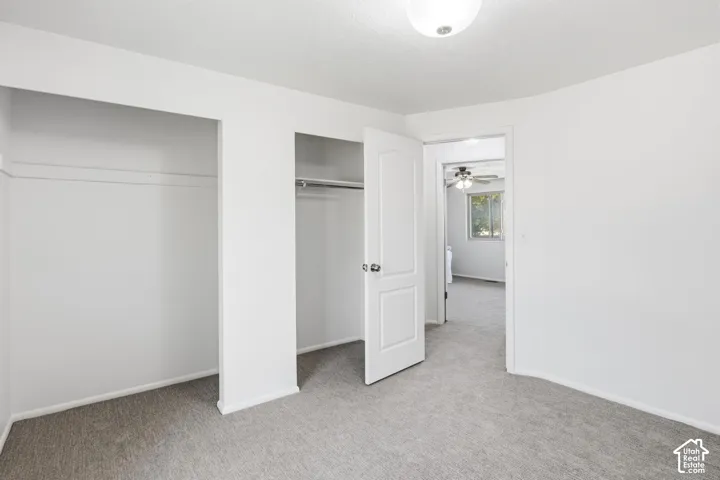 Neutral-toned wall-to-wall carpeting, dual reach-in closets with integrated shelving, and a six-panel interior door