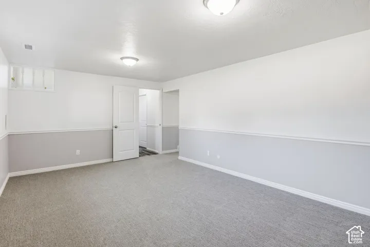 Room featuring neutral carpet, two-tone wall paint with chair rail molding, and recessed ceiling lighting