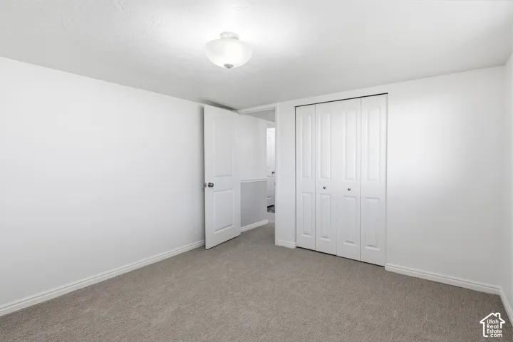 Neutral carpeting, white interior doors, and a built-in closet with four-panel folding doors