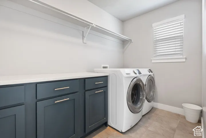 Utility room featuring dark-finish cabinetry, solid-surface countertop, full-width wall shelving, and tile flooring