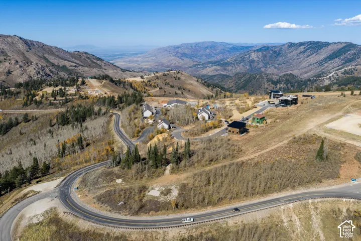 Aerial perspective of mountainous terrain featuring paved winding roads, elevated ridgeline topography, and dense patches of native vegetation