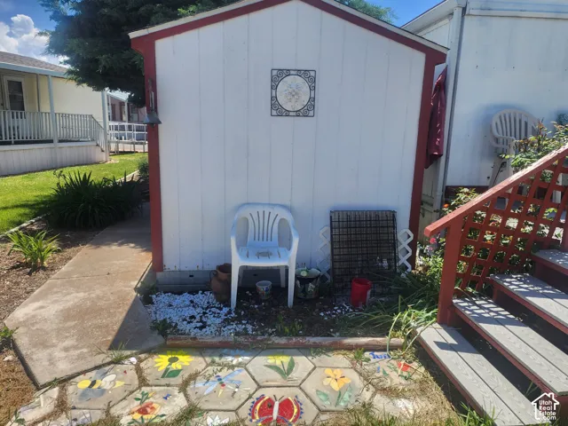 Storage structure with vertical siding, concrete walkway, and decorative hexagonal paver path