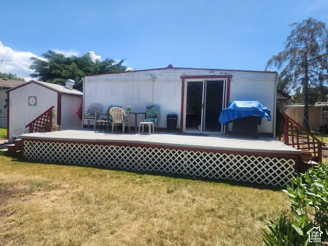 Elevated deck featuring lattice skirting, metal railings, and a sliding glass door exterior entry