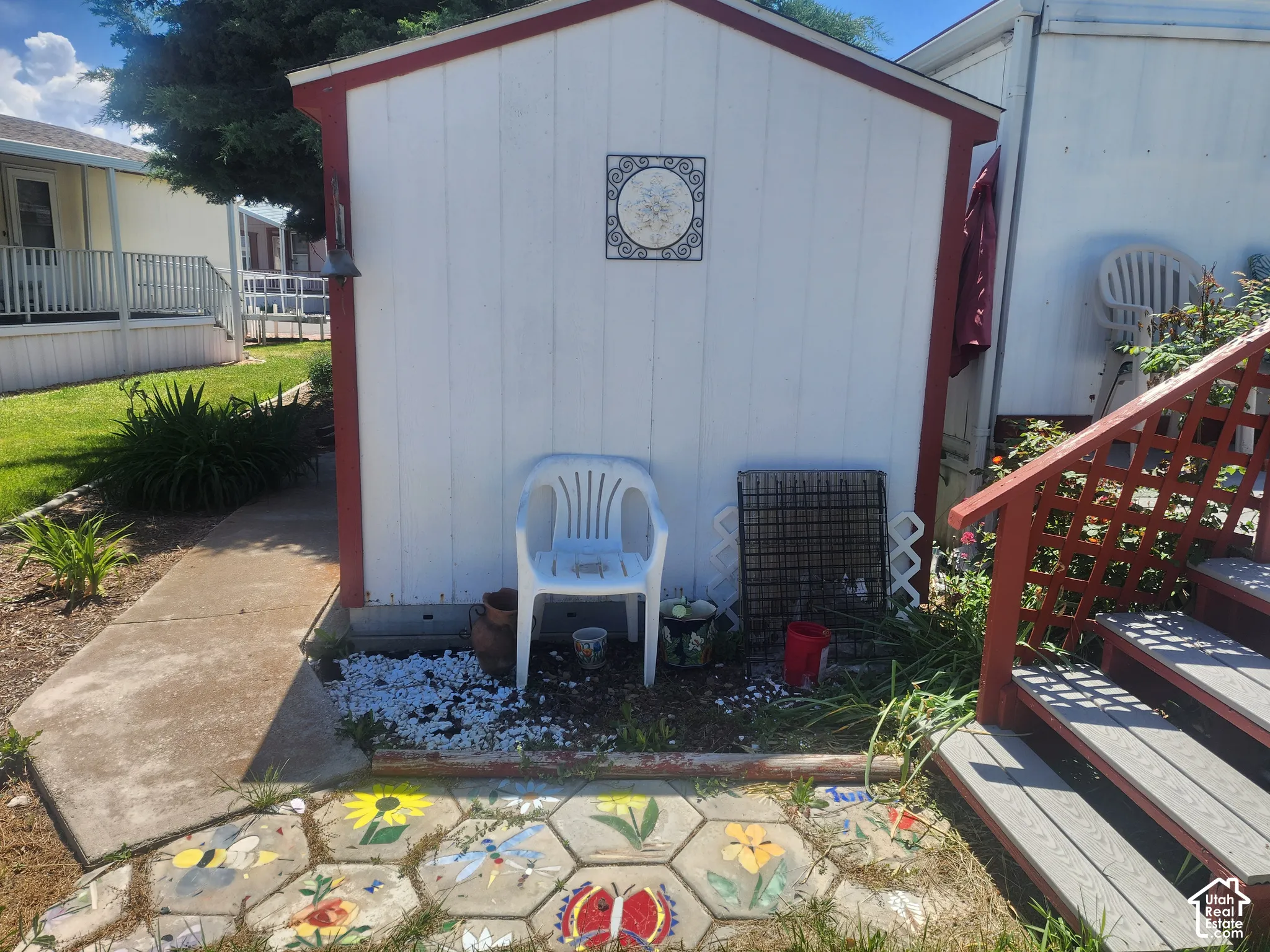 Storage structure with vertical siding, concrete walkway, and decorative hexagonal paver path
