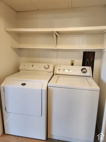 Laundry area featuring dual built-in shelving units and white vertical panel walls