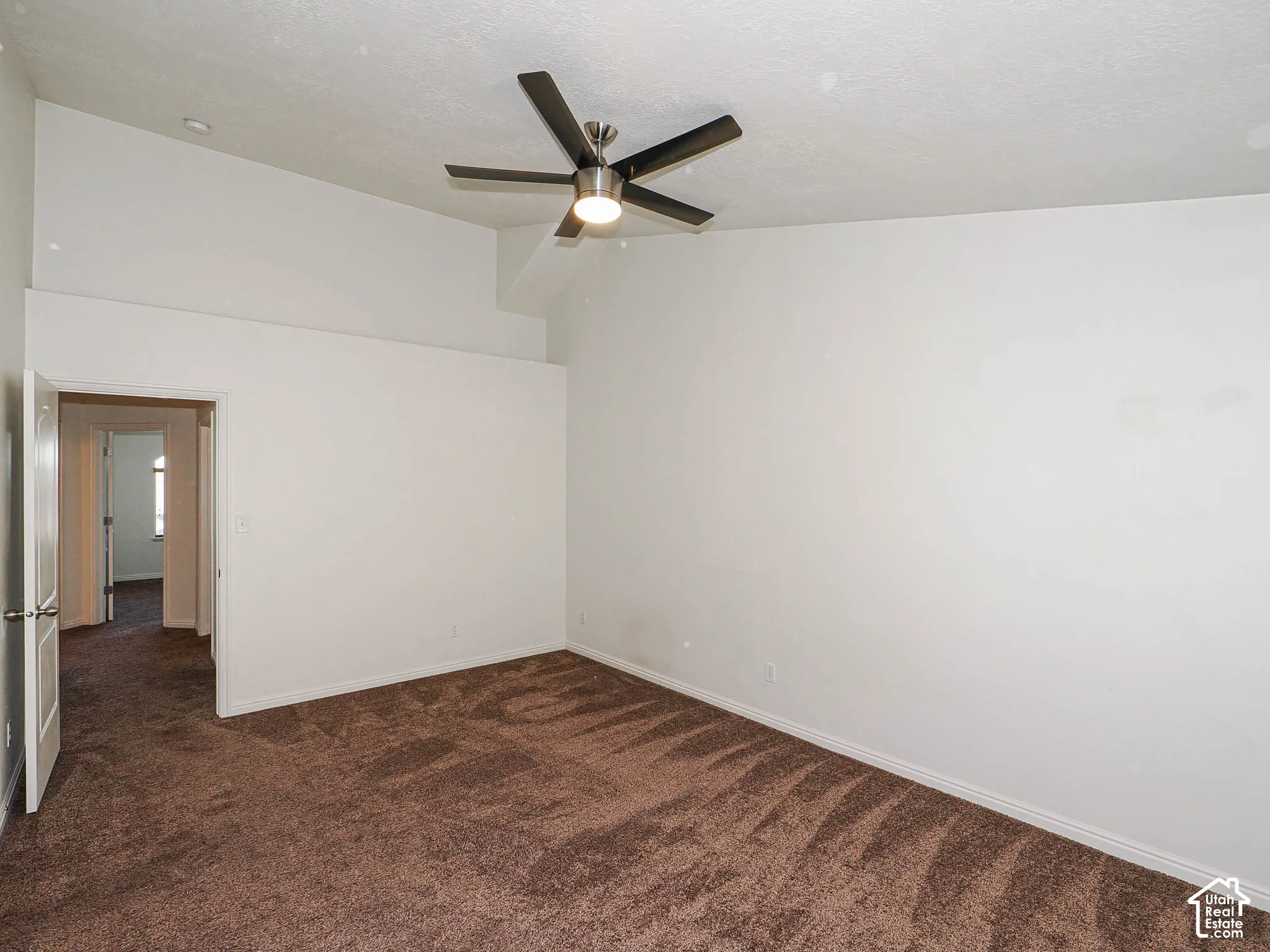 Vaulted ceiling, neutral wall finish, and overhead five-blade ceiling fan