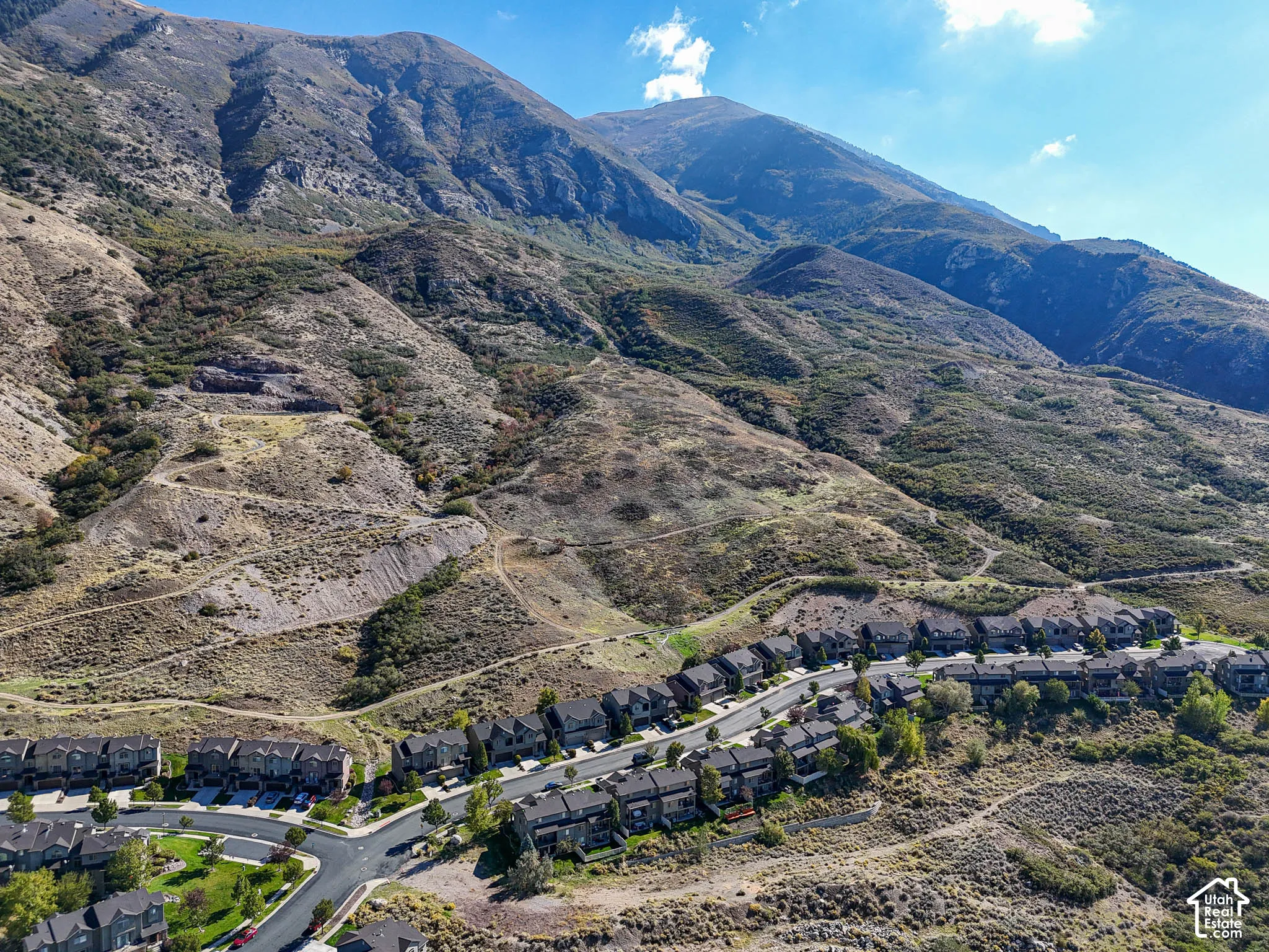 Aerial perspective featuring a multi-unit residential community situated at the base of expansive mountain terrain