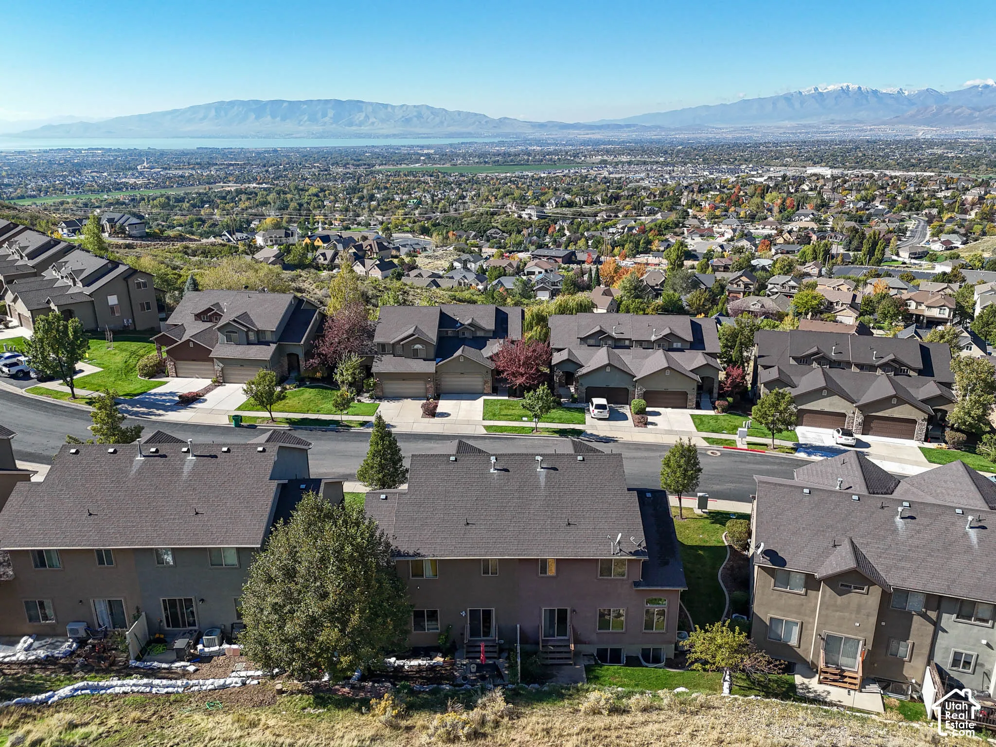 Aerial perspective of multi-level residential structures featuring asphalt shingle roofing, integrated garage spaces, and expansive mountain and valley scenery