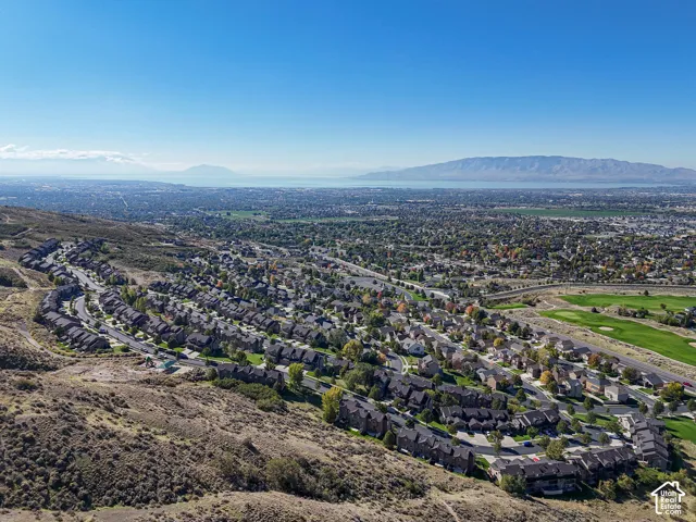 Aerial perspective featuring hillside topography, expansive valley landscape, and proximity to mountain ranges and a large lake