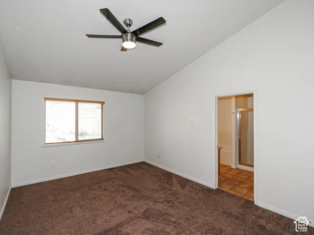 Vaulted ceiling, wall-to-wall carpeting, brushed metal ceiling fan with integrated light, and a double-pane window with horizontal blinds