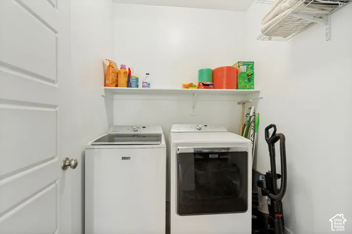 Laundry room featuring white paneled interior door, built-in wire shelving, and additional solid surface storage shelving