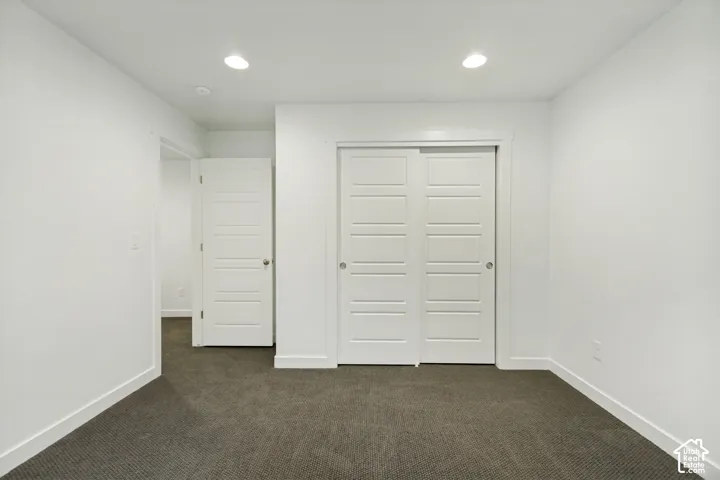 Neutral-toned carpeting, inset ceiling lighting, and solid-core interior doors with five-panel detailing