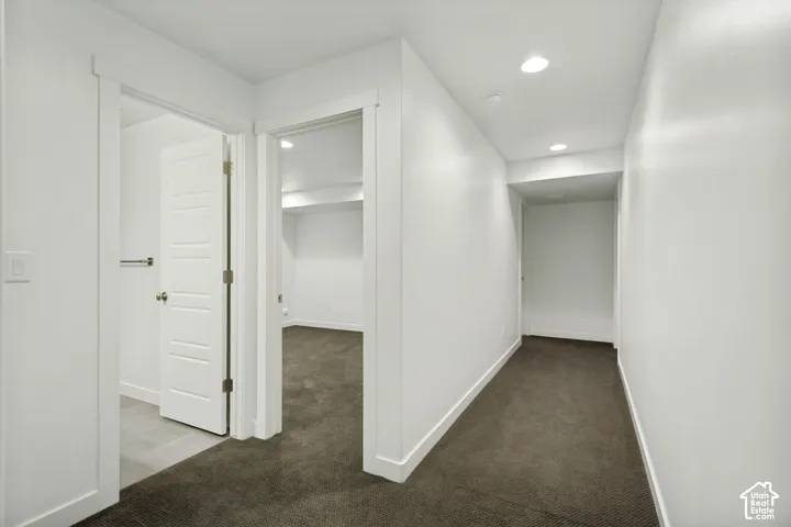 Neutral-toned carpeting, recessed ceiling lighting, and solid-core interior doors with crisp white trim