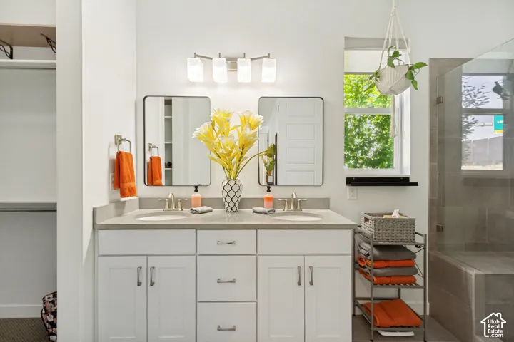 Dual-sink vanity featuring white cabinetry, solid-surface countertops, modern rectangular mirrors, and a brushed nickel light fixture