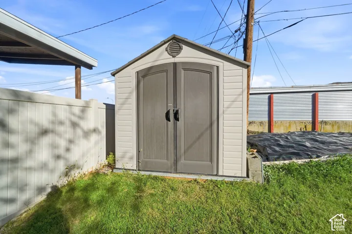 Freestanding storage shed featuring dual swinging doors, a gable roofline, and a circular gable vent