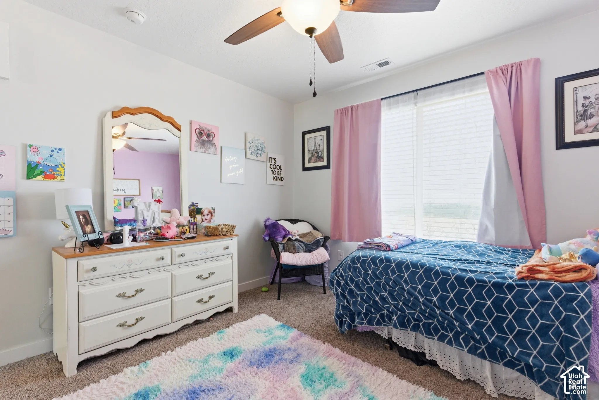 Bedroom featuring neutral wall paint, carpeted flooring, and a ceiling fan with integrated lighting
