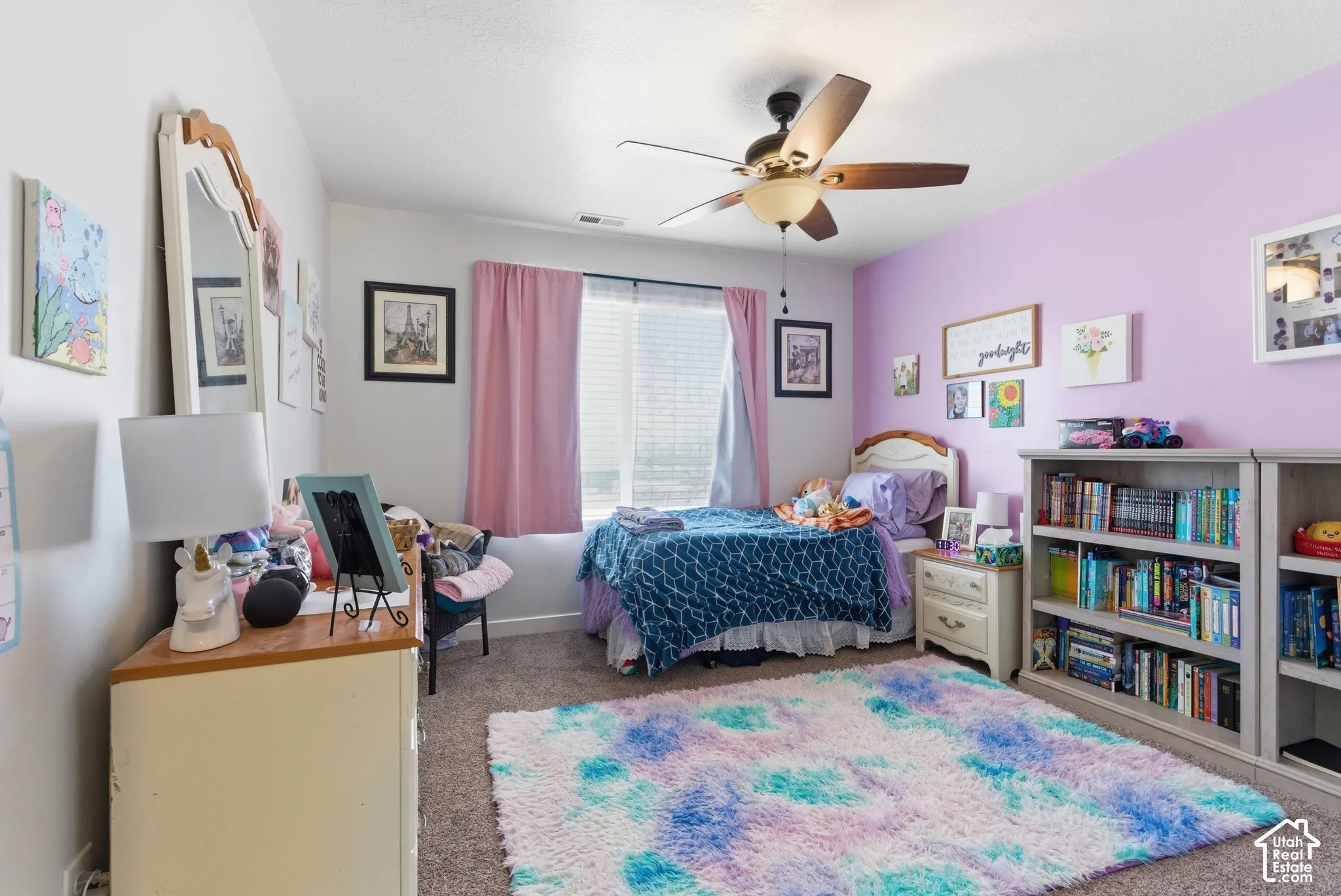Neutral wall tones with a feature accent wall, wall-to-wall carpeting, and a ceiling-mounted light fixture with integrated fan