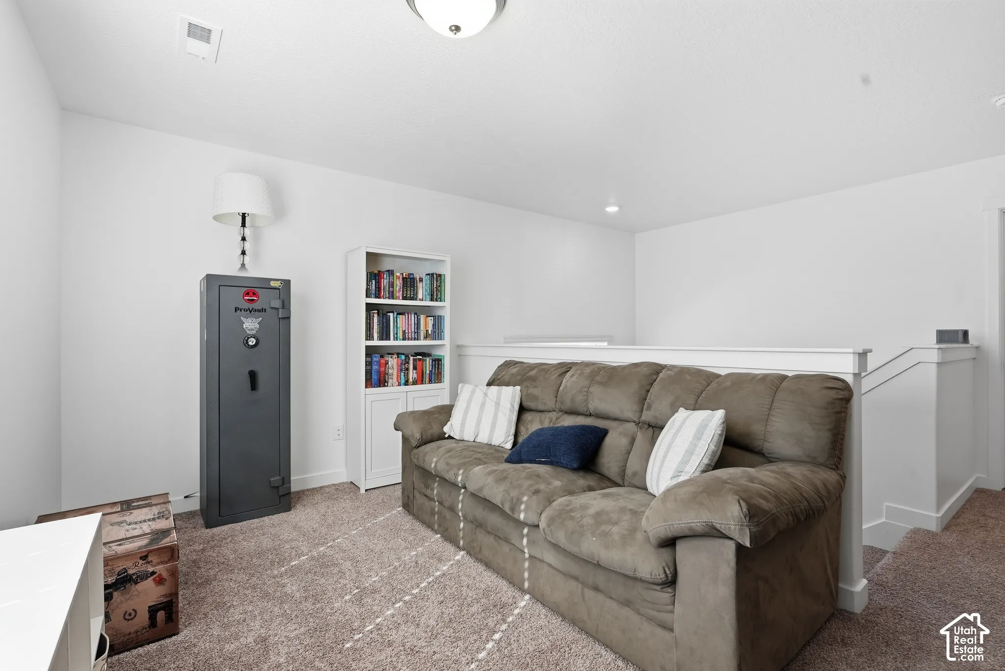 Neutral-toned carpet flooring, crisp white walls, and a painted wood half-wall railing