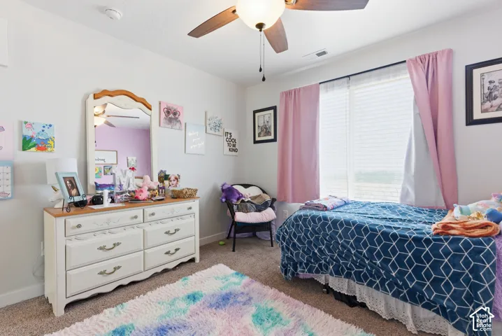 Bedroom featuring neutral wall paint, carpeted flooring, and a ceiling fan with integrated lighting
