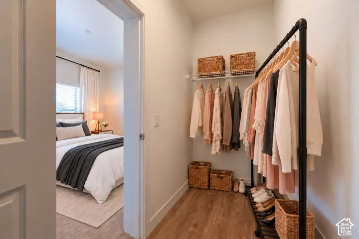 Walk-in closet featuring wire shelving and wood-finish flooring