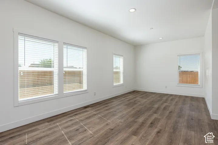 Neutral-toned interior featuring wood-finish flooring, recessed lighting, and multiple windows with white trim