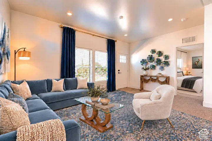Living area featuring recessed lighting, high ceilings, large windows, and a solid-core front entry door