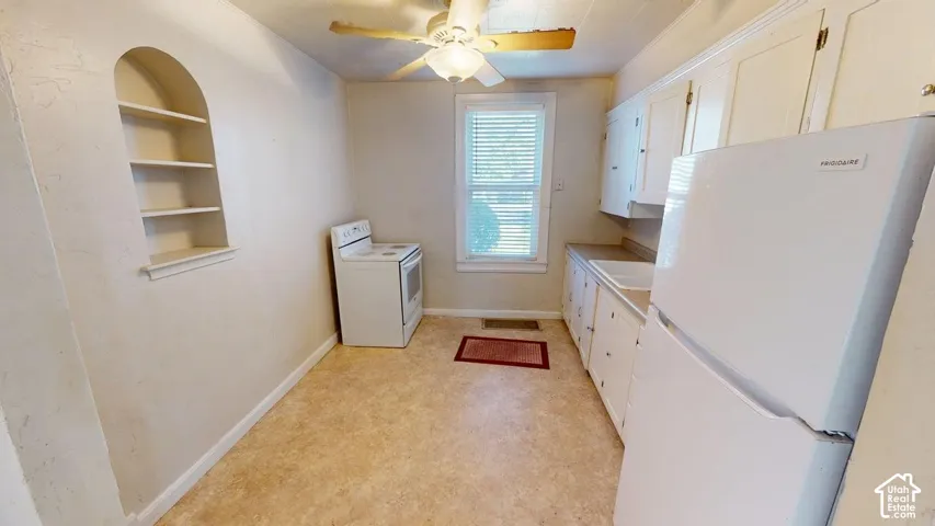 Kitchen featuring white cabinetry, an arched built-in wall niche, resilient flooring, and a ceiling-mounted light fixture