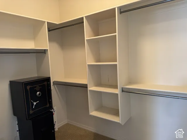 Walk-in closet featuring white built-in shelving and dual-level metal hanging rods