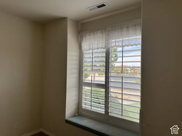 Recessed window nook featuring a built-in bench seat and plantation shutters