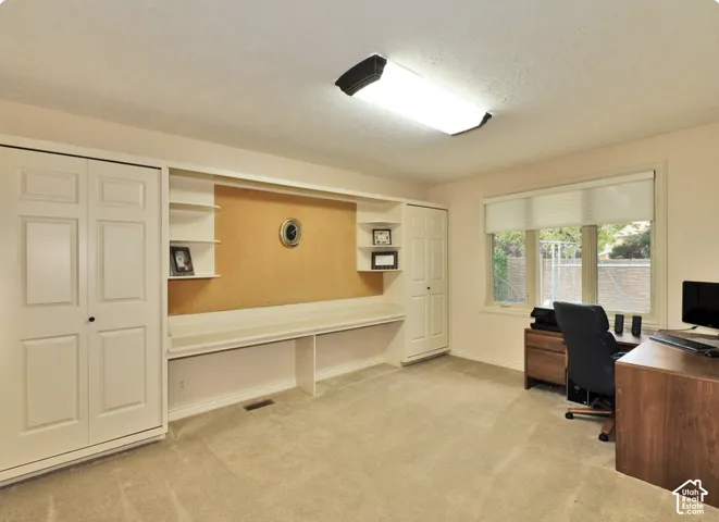 Built-in workstation featuring a full-width desk, upper shelving, and integrated cabinetry with paneled doors