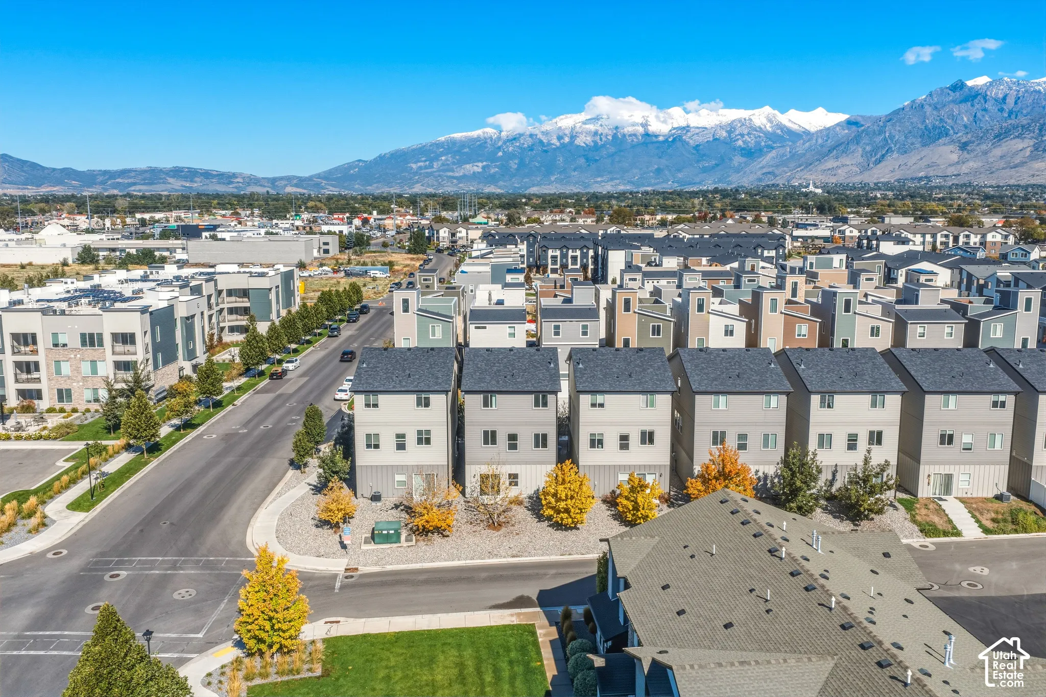 Multi-level residential structures featuring exterior neutral-toned siding, asphalt shingle roofing, and mountain backdrop scenery