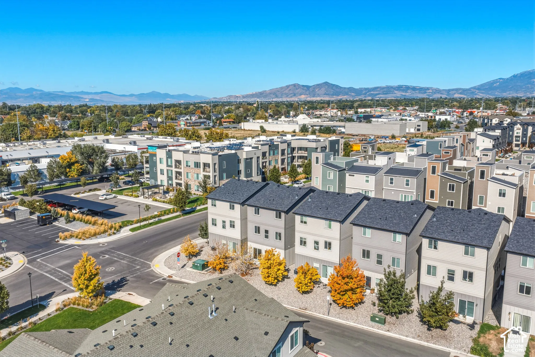 Aerial perspective showcasing a multi-level residential development with asphalt shingle roofing, structured exterior siding, and mountain backdrops
