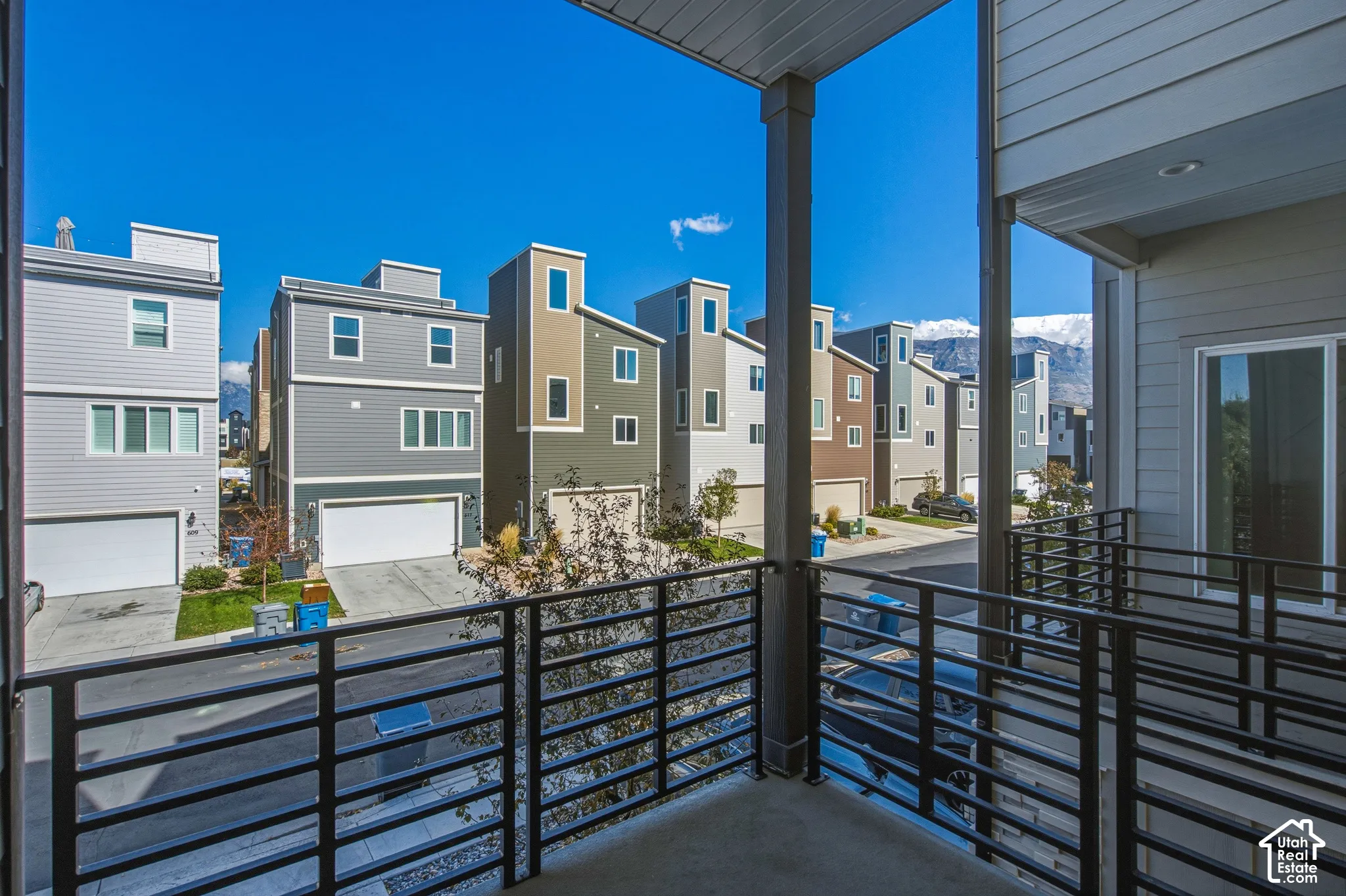 Covered balcony featuring black metal railings and overhead recessed lighting