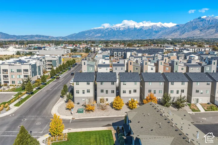 Multi-level residential structures featuring exterior neutral-toned siding, asphalt shingle roofing, and mountain backdrop scenery