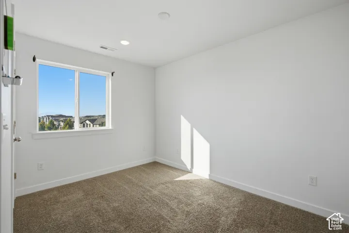 Room featuring neutral-toned carpeting, recessed lighting, and a single-pane window with a sill