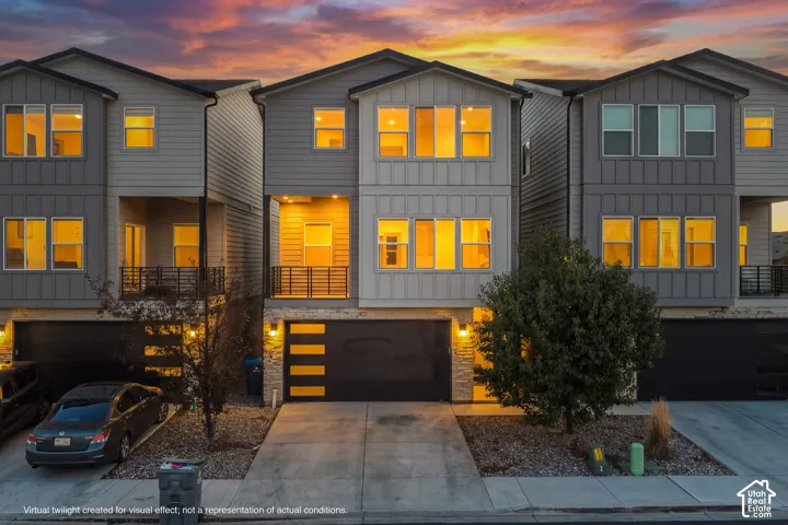 Multi-story contemporary exterior featuring board and batten siding, stone masonry accents, a private recessed balcony with metal railings, and an integrated multi-panel garage door