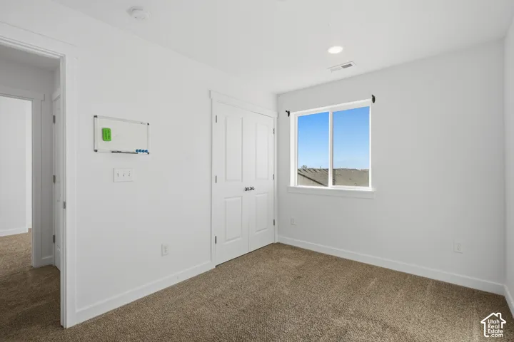 Neutral-toned wall-to-wall carpeting, white interior doors with brushed nickel hardware, and recessed ceiling lighting