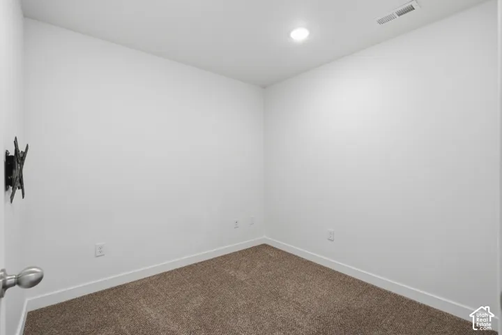 Neutral-toned room featuring neutral wall-to-wall carpeting and recessed ceiling lighting