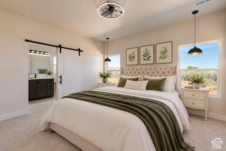 Sliding barn door with matte black hardware, recessed ceiling fan with integrated lighting, dual matte black pendant lights, and carpeted flooring
