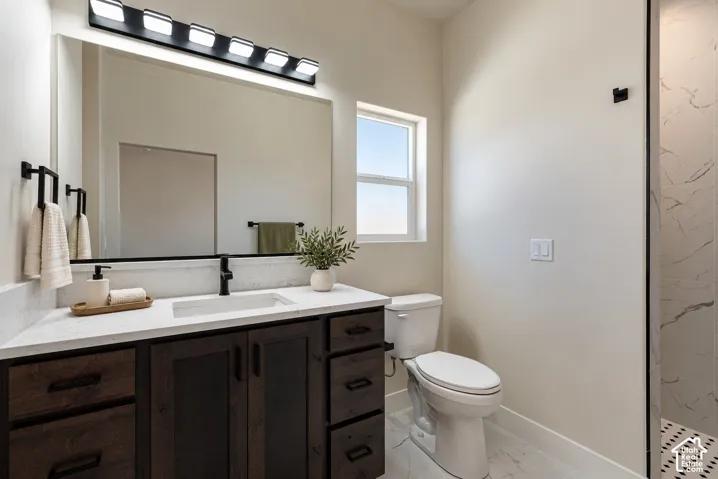 Bathroom vanity with dark wood-finish cabinetry, white stone-surface countertop, rectangular integrated sink, matte black faucet, and large wall-mounted mirror
