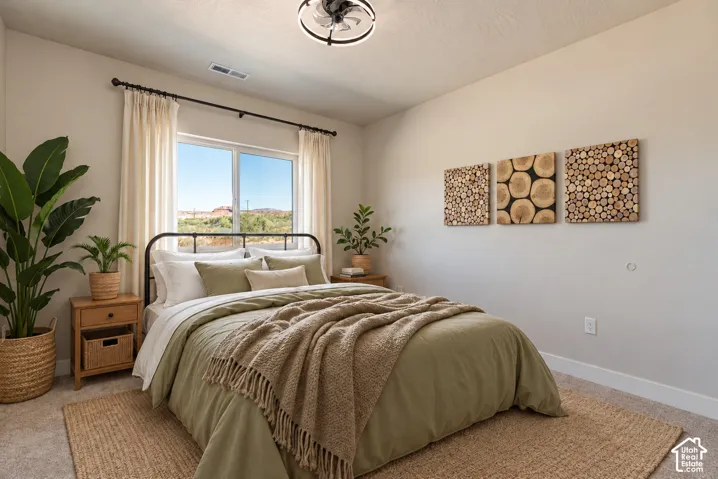 Neutral wall tones, carpeted flooring, sliding window with horizontal desert landscape, and industrial-style flush mount ceiling light