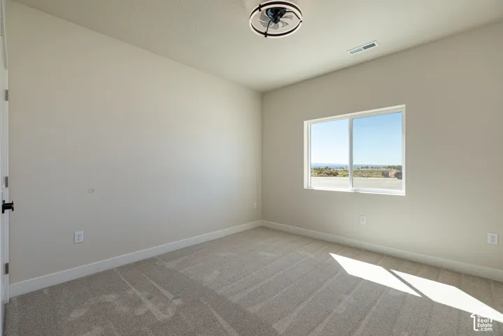 Neutral-toned walls complement the light-colored carpet flooring
