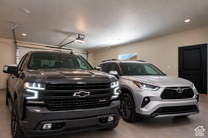 Attached garage featuring finished interior walls, recessed lighting, and a solid-core door