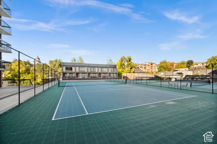 Outdoor tennis courts featuring modular athletic surfacing and perimeter chain-link fencing