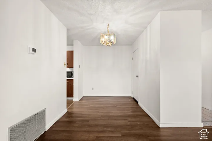 Interior space featuring wood-finish flooring, a multi-tiered crystal chandelier, and a solid-core interior door