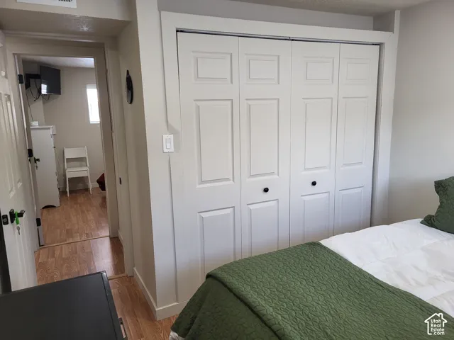 Four-panel bi-fold closet doors with matte black hardware and wood-finish flooring