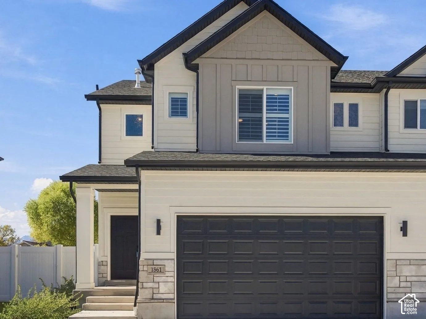 Twin home located in Overlake Community.  Multi-level exterior featuring a combination of horizontal lap siding and vertical board-and-batten siding, stone veneer accents, an attached two-car garage, and dual-gabled rooflines