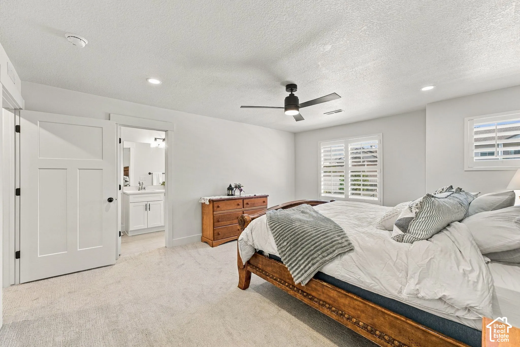 Neutral interior featuring recessed lighting, a matte black ceiling fan, plantation shutters, and a three-panel interior door