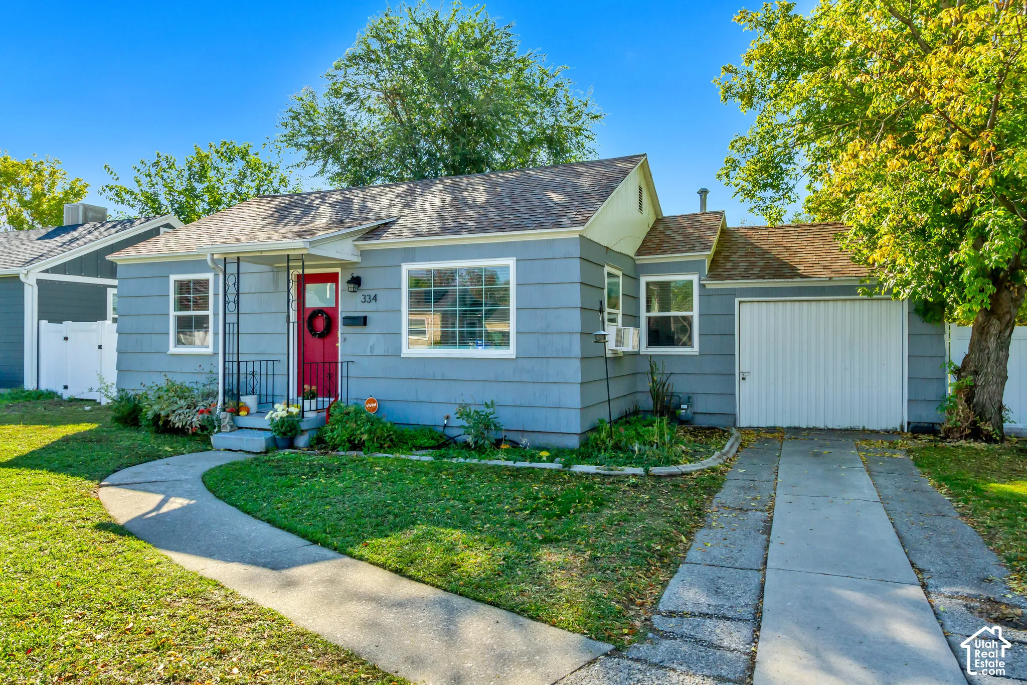 Single-story residence with lap siding, asphalt shingle roof, concrete driveway, attached garage, and covered entryway